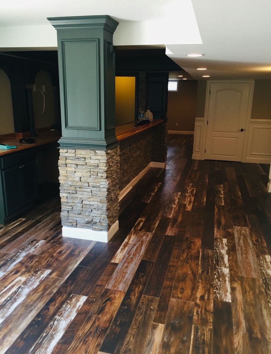 Reclaimed wood flooring with stone bar by East Coast Floors